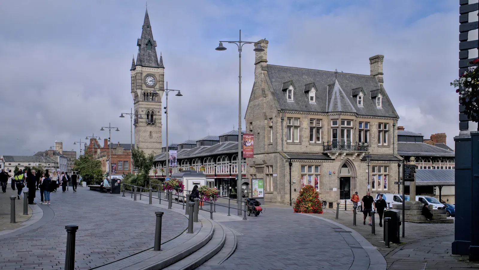 Darlington town centre, with the Victorian clock tower and the covered Market Hall standing behind the stone Old Town Hall, seen across the paved square